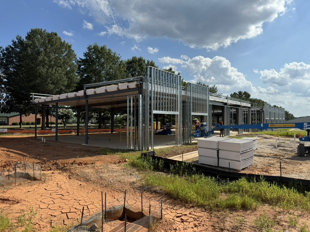 Exterior cold-formed metal framing on a commercial building with framing material staged for installation